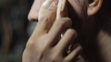 Yüzüne puf puf üfleyen bir kadın. Temeli kusursuz bir cilt için kabartmayla harmanlayan bir kadının yakın çekimi.