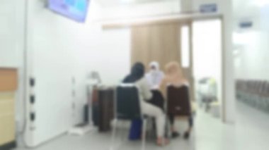 Yumuşak odaklı bir kompozisyon, hastane ya da klinik ortamında iki kadınla bir doktorun buluştuğunu gösteriyor. Genel ses tonu, özel bir sağlık danışmanlığı veya sağlık tartışması önermektedir..