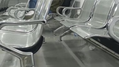 Bir perspektif görünümü, insanların dinlenebileceği ya da düşünebileceği, halka açık bir alanda düzenli bir bekleme duygusunu vurgulayan, düzenli bir sıra halinde dizilmiş şık krom sandalyeleri içerir..