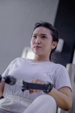 Kararlı bir kadın enerjisini kürek çekme makinesine odaklar, dayanıklılığını ve ev ortamında spor yaparak sağlıklı bir yaşam tarzını şekillendirir..