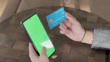 Bir telefon ve kredi kartıyla ödeme işleminin kolaylığını yakalayın. Görüntü, tüketiciler için sorunsuz işlemler ve modern finans teknolojisini vurguluyor.