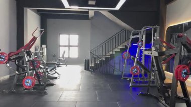 Bir spor salonunun görüntüsünde modern bir estetik, gösterişli ekipmanlar ve el değmemiş bir çevre, dayanıklılık eğitimi ve tam vücut kondisyonu için tasarlanmış..