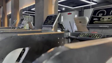 Modern bir spor salonunda düzenli olarak koşu bantları kullanılıyor. Sağlam bir spor programı sunuluyor. Gösterişli ekipman, çalışma ortamını geliştiren teknolojiyi sergiliyor.