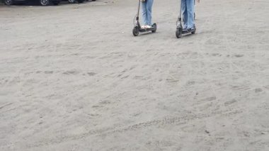 Elektrikli scooter sürerken yakalandı. Bir insan toprak yolda kısa bir yolculuk için scooter kullanır. Bu kişisel kentsel hareketlilik ve ekolojik bilinci gösteriyor.