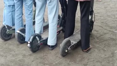 Elektrikli scooter sürerken yakalandı. Bir insan toprak yolda kısa bir yolculuk için scooter kullanır. Bu kişisel kentsel hareketlilik ve ekolojik bilinci gösteriyor.