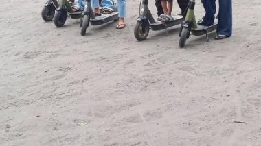 Elektrikli scooter sürerken yakalandı. Bir insan toprak yolda kısa bir yolculuk için scooter kullanır. Bu kişisel kentsel hareketlilik ve ekolojik bilinci gösteriyor.