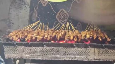 Sıcak kömürlerin üzerinde ızgara yapan otantik Endonezya yemeğini deneyin. Bu ağız sulandırıcı yemek lezzeti yerel baharatlarla hazırlanmış lezzetli et şişleri sergiliyor..