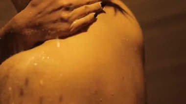 Altın saat sükuneti, sıcak ışıkta yıkanmış bir kadın duş sahnesi, yumuşakça tenini okşuyor ve rahatlatıcı bir şey sunuyor.