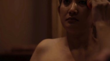 Samimi rutin olarak, bir kadın makyajını konsantrasyon ve hassasiyetle yapar.