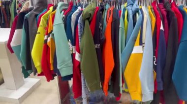 Erkek çocuk giysi koleksiyonu elbise dükkanındaki askıda.