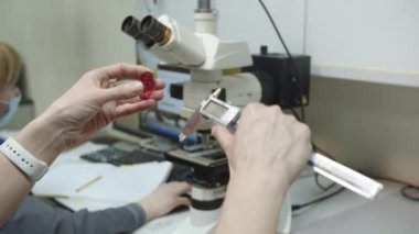 Elektronik kalibreli kırmızı termal çamaşır makinesi kalınlığı ölçülüyor. Polimer ürünlerinin laboratuvar araştırması. Ürün parametreleri kontrol ediliyor