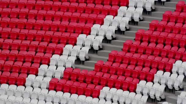 スポーツアリーナのトリビューンの近くの通路の視聴者のための赤と白の席 スポーツイベントや競技会のために用意された大スタジアム — ストック動画