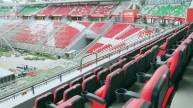 Seyirciler için kırmızı ve siyah koltukları olan büyük bir spor stadyumu. Modern yüzme havuzu yarışmalar için inşaat sürecinde