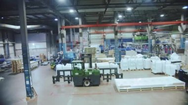 Makine ekipmanları ve fabrika atölyesinde yere yığılmış polikarbonat çarşafları. Sanayi fabrikasında plastik madde üretimi