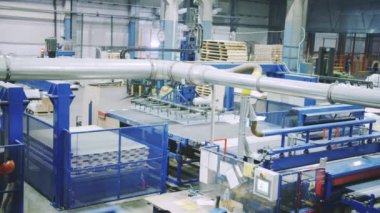 Polimer üretim tesisinde manipülatör ve borular kullanıyor. Modern plastik madde fabrikasının atölyesinde profesyonel makine ekipmanları