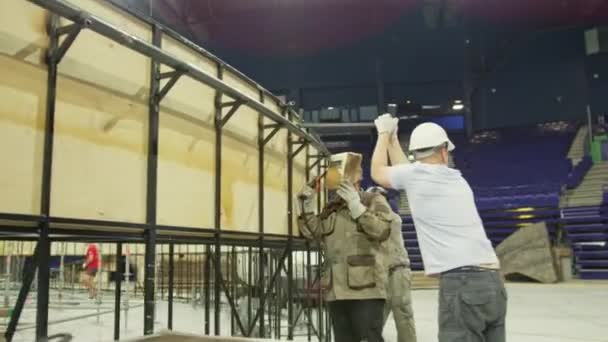 現代のスポーツアリーナで巨大なスイミングプールのアシスタント溶接金属死体と労働者 建設現場で働く熟練した建築家 — ストック動画