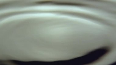 Parlak güneş ışığında şiddetli yağmur damlalarından gelen titreşimler ve sıçramalar. Temiz yağmur damlaları göletin su yüzeyine çok yakın mesafeden düşer.