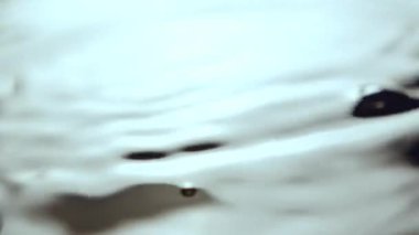 Parlak güneş ışığı gölün dalgalı su yüzeyine yansıyor. Taze yaz yağmurları gölete düşer ve ışık dalgalarını aşırı yakınlaştırır.