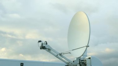 TV yayını için SNG uydu bağlantısı kamyonu. Bulutlu gökyüzüne karşı yayın yapmak için aracın çatısında anten uydusu var.