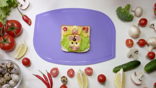健康的三明治 形状有趣的狗躺在紫色的切菜板上 夹杂着沙拉 西红柿和奶酪的小吃 — 图库视频影像