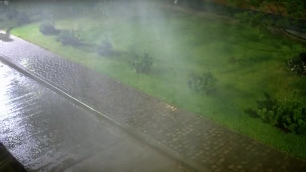 穿着轻薄的年轻女子在暴风雨中很快地从小巷里跑了出来 洪水在道路上和靠近绿色草坪的人行道上产生了水坑 — 图库视频影像