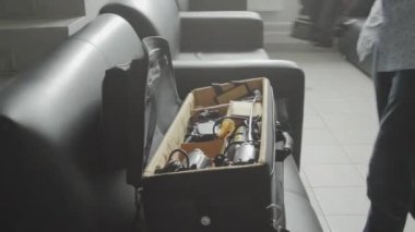 Profesyonel kameraman ekipmanları siyah bavula yerleştirir. Fotoğrafçı, tema çekimi için gerekli araçlarla özel çanta araştırıyor