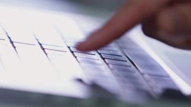 Erkek serbest çalışanın parmağı bulanık arka planda modern dizüstü bilgisayarın klavyesinde düğmelere basıyor. Elektronik aygıtla ilgili yazıyı insan tipi kapatma