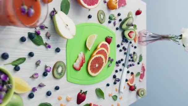 Čerstvé Grapefruitové Plátky Zelené Řezací Desce Obklopené Různými Druhy Ovoce — Stock video