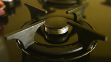 Birisi gaz ocağını açar ve kahve makinesini siyah ocağa koyar. Ev hanımı üretken bir güne başlamak için lezzetli bir kahve yapmak istiyor.