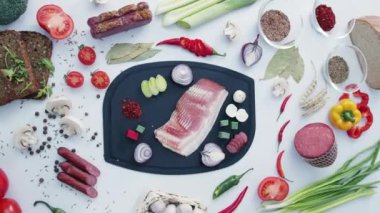 Masadaki plastik kesme tahtasının üzerinde domuz pastırması ve sebze kes. Mutfakta yemek pişirme ve sağlıklı yemek yapma hazırlığı