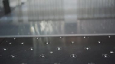 Makine fabrikadaki polikarbonat panellerini keser. Küçük kırıntılar şeffaf sayfalardan ayrılır. Modern endüstriyel üretimde otomatik ekipman