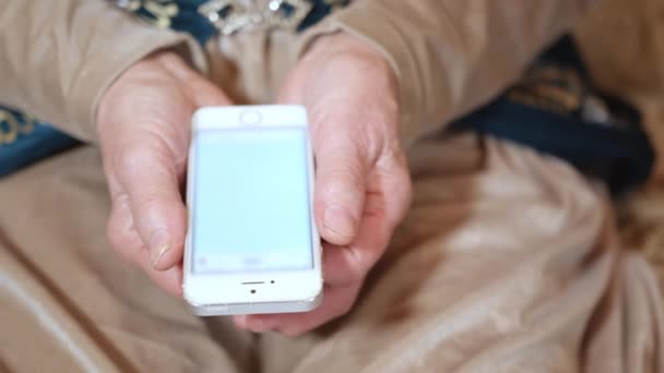 高齢者の女性は 現代のスマートフォンを介してソーシャルメディアで写真メッセージを受け取ります 電子機器を持つおばあちゃんのしわの手を閉じる — ストック動画