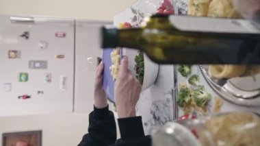 Ev hanımı mutfaktaki plastik kesim tahtasına doğranmış peynir koyar. Kadın evde taze sebzelerle sağlıklı salata hazırlıyor.