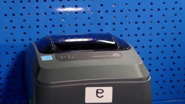 Endüstriyel şirket deposunda barkodlu özel üretim cihazı baskısı makbuzu. Termal barkod yazıcısı depo duvarında asılı