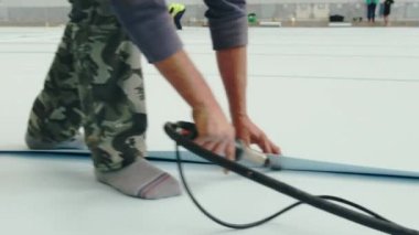 Uzman yüzme havuzu için döşeme aletleri kullanıyor. İnsan, profesyonel ekipmanlarla beyaz kaplama işlemlerini bitirir.