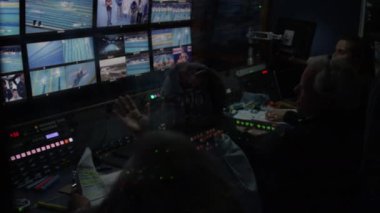 ALMATY, KAZAKHSTAN - SEPTEMBER 14 Eylül 2020: Yorumcular spor müsabakalarını canlı yayında tartıştılar ve senaryoları video monitörleri duvarı ve görüş mikseriyle 14 Eylül 'de Almaty' de yarı karanlık bir önermede karşılaştırdılar