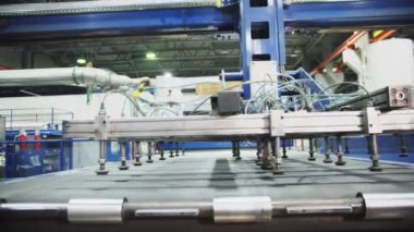 Modern fabrikadaki taşıma sistemi. Vakumlu vakum kapları olan manipülatör, taşıma bandının üzerine yerleştiriliyor. Panel ürünlerinin etkin şekilde taşınması