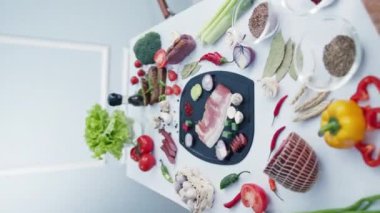 Evde plastik kesim tahtasında öğle yemeği pişirmek için et ve sebze. Doğranmış malzemeler masanın üzerinde duruyor.