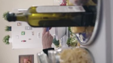 Kadın, plastik kesme tahtasından peyniri taze sebzelerle salata kasesine koyar. Ev hanımı sağlıklı salataya doğranmış peynir ekler.