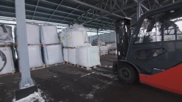 工人们用电动叉车提起并搬运建筑材料包 装有现代聚碳酸酯面板和薄膜线圈的仓库 — 图库视频影像