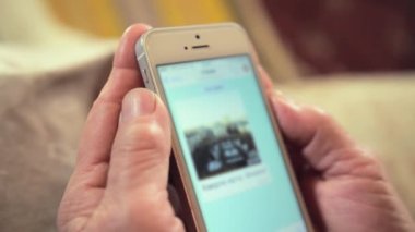 Modern akıllı telefon ve geçmişi bulanık yaşlı bir kadının buruşuk elleri. Emeklinin iletişim için kullandığı cihaz çok yakın plan.