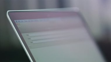 KYIV, UKRAINE - SEPTEMBER 27 2021: Freelancer modern dizüstü bilgisayarda yazarak web sitesindeki boşlukları dolduruyor. Bulanık arkaplanda elektronik aygıtın ekranı