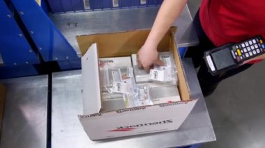 ALMATY, KAZAKHSTAN - 14 Eylül 2020: Depo çalışanı taşınabilir veri terminali ve taşınabilir ögeler ile ürün taramasıyla ilgilenir. Kadın çalışan süreçleri işyeri demir masasında mal aldı