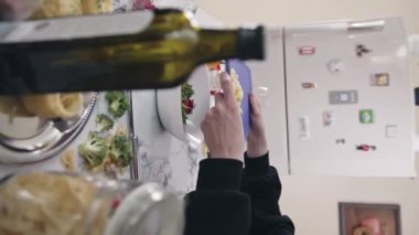 KYIV, UKRAINE - 27 Eylül 2021: Kadın mutfakta doğranmış peynirli sağlıklı salata hazırlıyor. Ev hanımı kesim tahtasındaki malzemeleri koyar ve sebze salatası yapar.