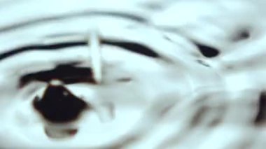 Damlacıklar düşer ve temiz suda ilginç daireler çizerler. Kalın su damlaları düşer ve şeffaf sıvı yüzeyi sallar