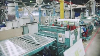 Polimer fabrikasının atölyesinde monolitik polikarbonat çarşafları için modern taşıyıcılar. Üretim tesisinde profesyonel makine ekipmanları