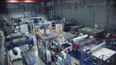 KYIV, UKRAINE - 27 Eylül 2021: Modern fabrika atölyesinde polimer malzemesi üretimi için profesyonel ekipman. Üretim fabrikasının üst görüntüsünde polikarbonat kağıtları üretimi