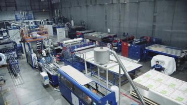 KYIV, UKRAINE - 27 Eylül 2021: Endüstriyel fabrika atölyesinde makine ekipmanları ve polikarbonat katmanları. Modern üretim tesisinde polimer materyallerin üretimi