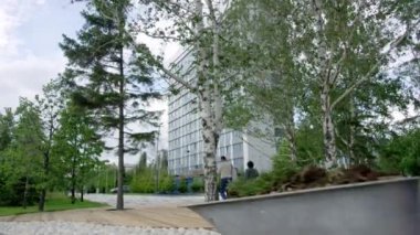 Üniformalı eleman parktaki son çöpleri de atıyor. İnsanlar etrafta dolaşıp ağaçların ve filizlerin arasında yeni yapılmış bir park inşa ediyorlar.