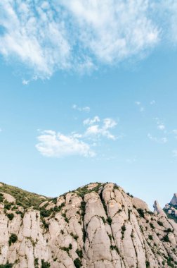 Parlak mavi gökyüzünün altındaki görkemli yüksek dağ zirveleri.